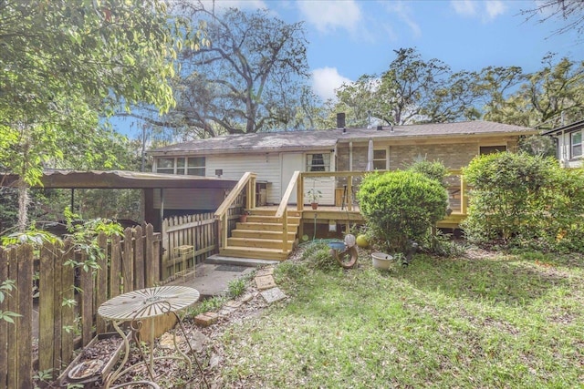 back of property with fence and a wooden deck