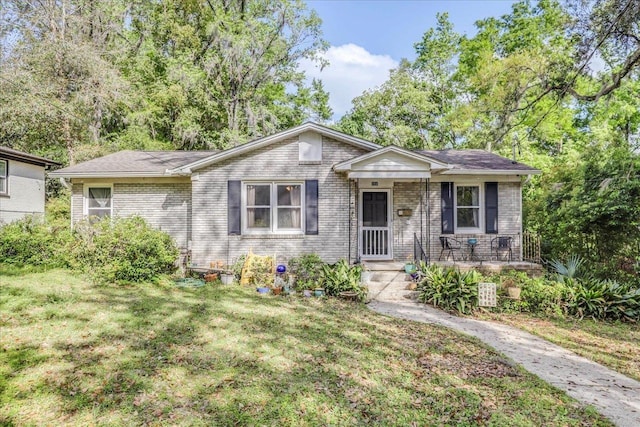 bungalow-style house with brick siding and a front yard