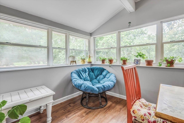 sunroom featuring baseboards, lofted ceiling with beams, and wood finished floors