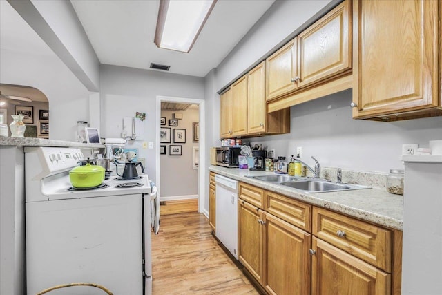 kitchen featuring a sink, light wood-style floors, white appliances, light countertops, and visible vents