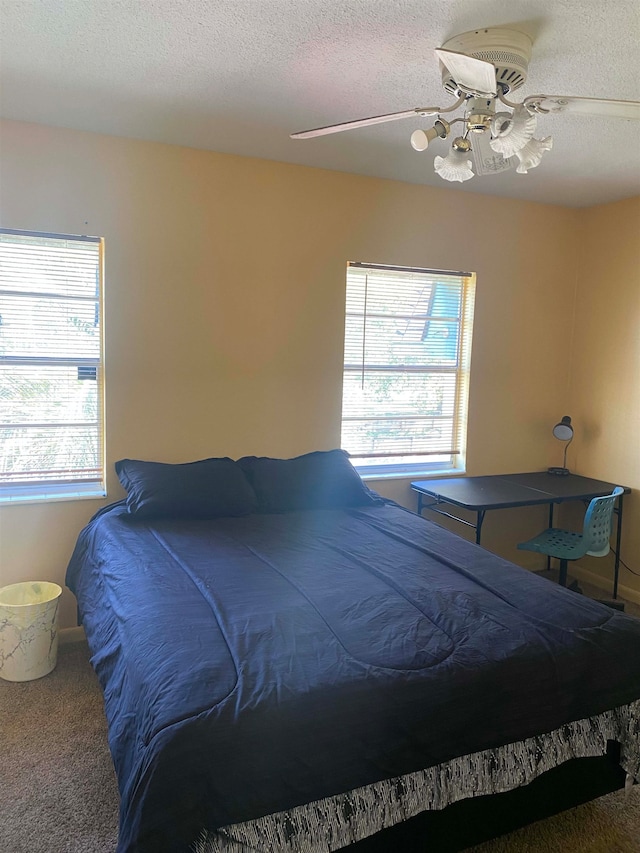 bedroom featuring carpet flooring, ceiling fan, and a textured ceiling