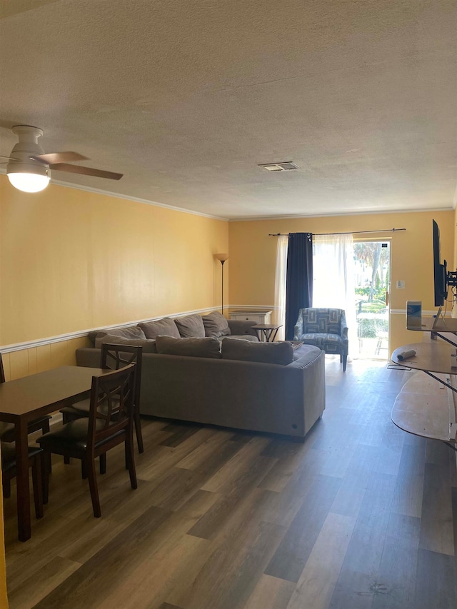 living room with ceiling fan, dark hardwood / wood-style flooring, and a textured ceiling