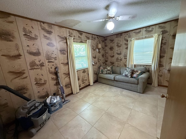 interior space featuring light tile patterned floors, ceiling fan, and a textured ceiling
