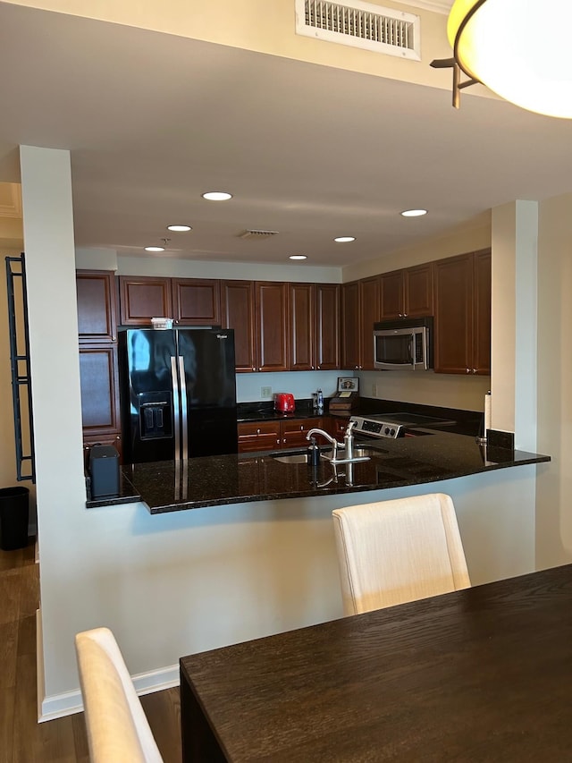 121 N Monroe St Unit 8007, Tallahassee, FL 32301 - kitchen featuring stainless steel microwave, black refrigerator with ice dispenser, a sink, dark stone countertops, and a peninsula