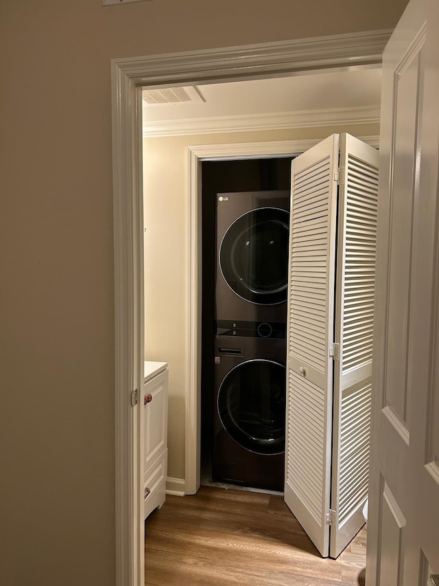 121 N Monroe St Unit 8007, Tallahassee, FL 32301 - laundry room with stacked washer / dryer, wood finished floors, ornamental molding, and baseboards
