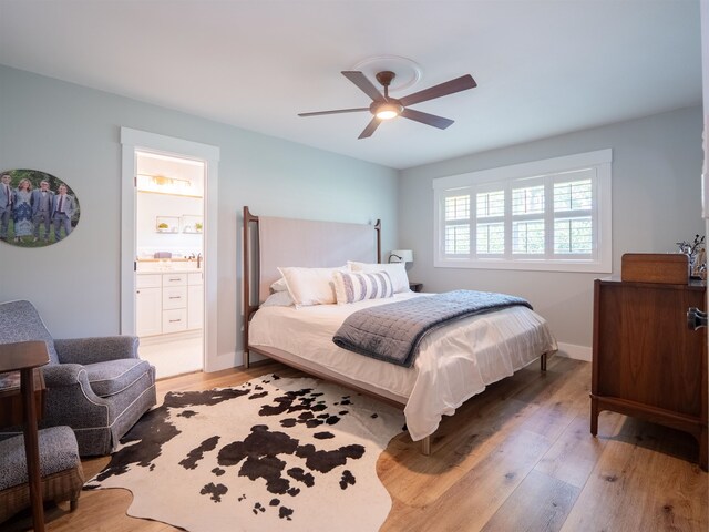 bedroom featuring connected bathroom, hardwood / wood-style flooring, and ceiling fan