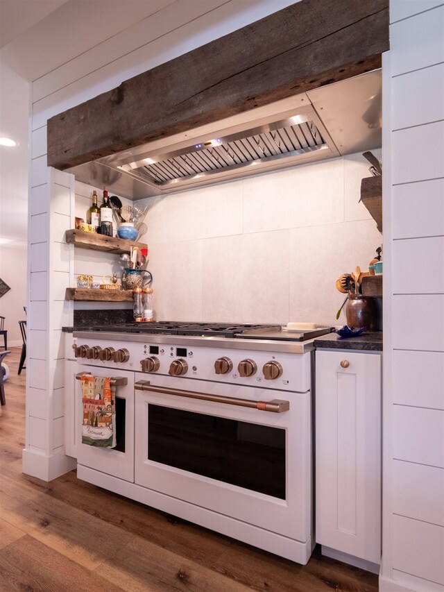 kitchen featuring white cabinetry, dark wood-type flooring, exhaust hood, and gas stove