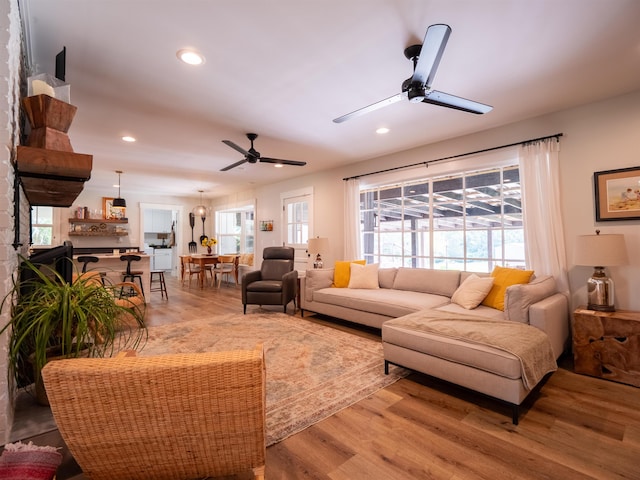 living room with a wealth of natural light, hardwood / wood-style flooring, and ceiling fan