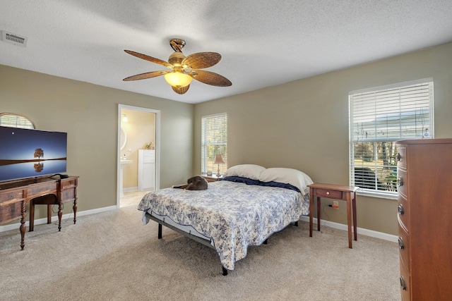 bedroom featuring light carpet, ceiling fan, and a textured ceiling