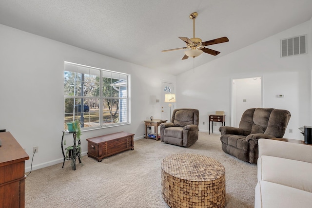 living room featuring lofted ceiling, a textured ceiling, light colored carpet, and ceiling fan