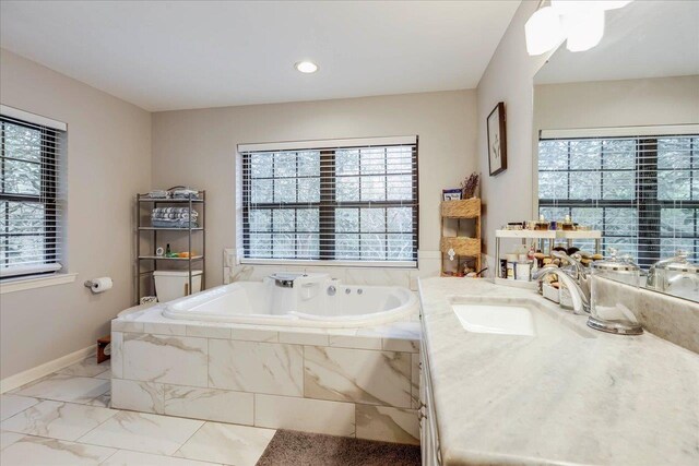 818 Watt Dr, Tallahassee, FL 32303 - bathroom with baseboards, marble finish floor, a garden tub, and a healthy amount of sunlight