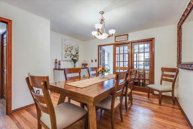 818 Watt Dr, Tallahassee, FL 32303 - dining area featuring baseboards, light wood-style flooring, and a notable chandelier
