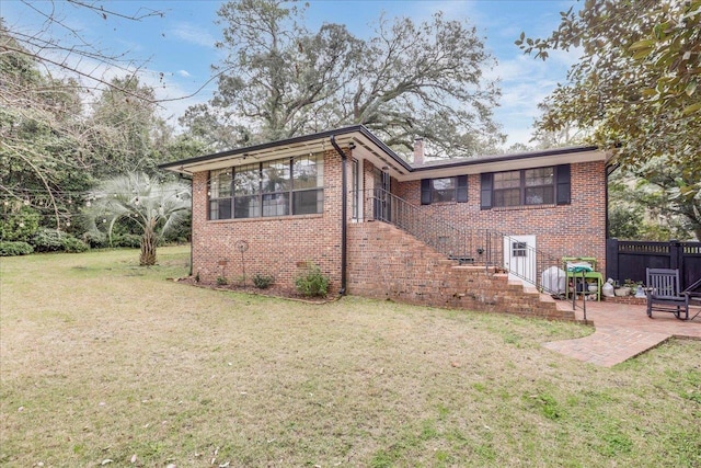 818 Watt Dr, Tallahassee, FL 32303 - view of front of property with a patio, brick siding, fence, stairway, and a front yard