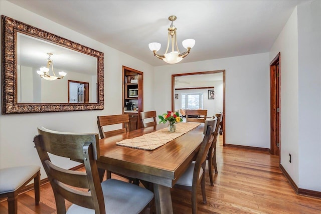 818 Watt Dr, Tallahassee, FL 32303 - dining area with an inviting chandelier, baseboards, and light wood-style floors
