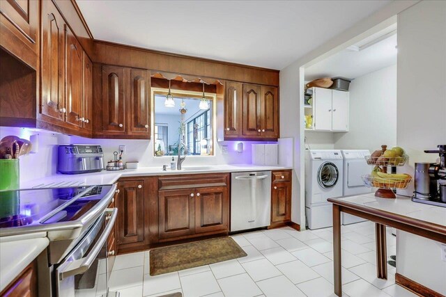 818 Watt Dr, Tallahassee, FL 32303 - kitchen featuring stainless steel appliances, a sink, light countertops, independent washer and dryer, and brown cabinetry