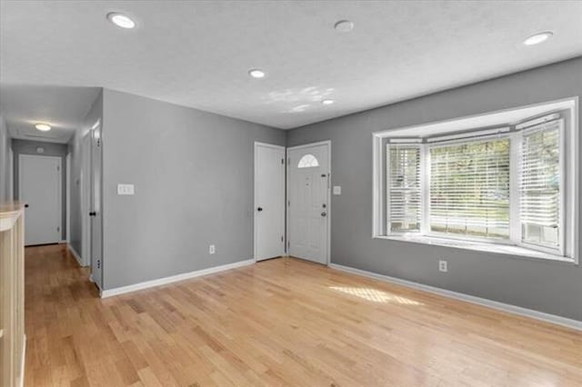 foyer featuring light wood-style floors, baseboards, and recessed lighting