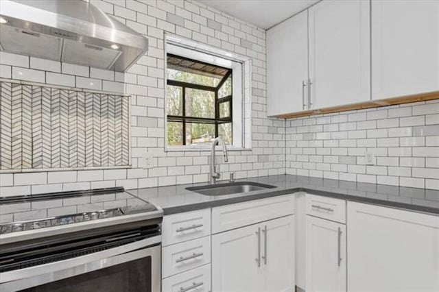 kitchen with dark countertops, electric stove, white cabinets, and ventilation hood