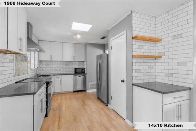 kitchen with open shelves, stainless steel appliances, white cabinetry, a sink, and wall chimney exhaust hood