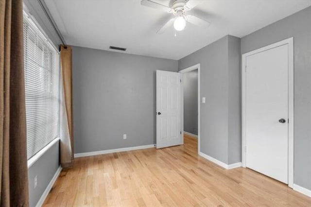 unfurnished bedroom featuring a ceiling fan, light wood-type flooring, visible vents, and baseboards