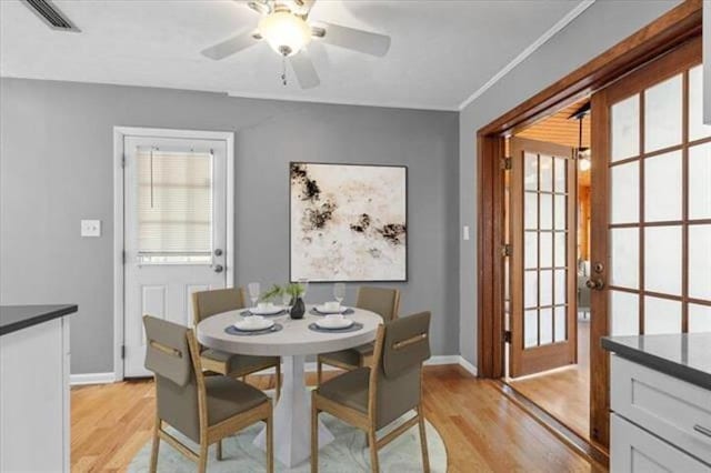 dining space with light wood-style floors, visible vents, and baseboards