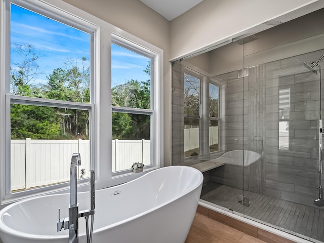 bathroom with hardwood / wood-style flooring and plus walk in shower