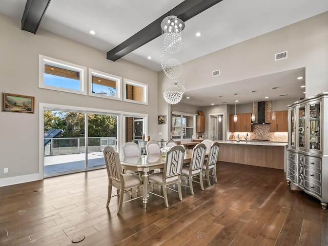 dining area with beam ceiling, a chandelier, a high ceiling, and dark hardwood / wood-style floors