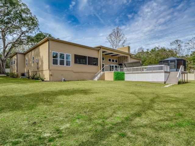 back of property featuring a lawn, cooling unit, and a sunroom