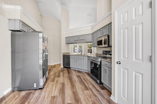 kitchen with gray cabinets, stainless steel appliances, dark hardwood / wood-style floors, and stone counters