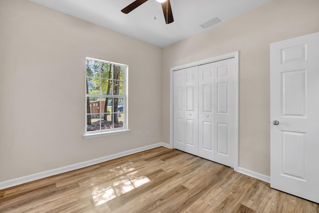 unfurnished bedroom featuring ceiling fan, light hardwood / wood-style floors, and a closet