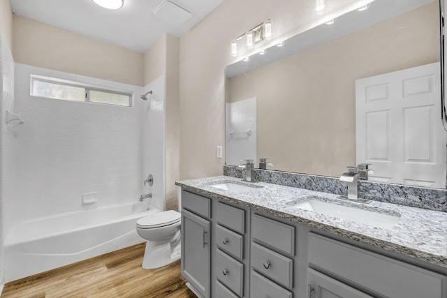 full bathroom with vanity, hardwood / wood-style flooring, shower / tub combination, and toilet