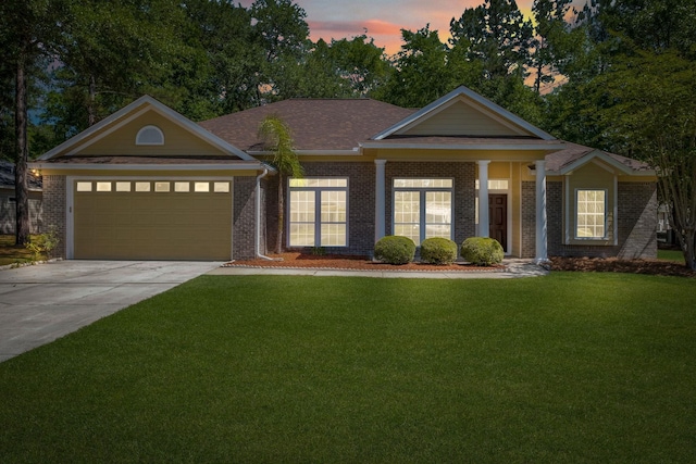 view of front of property featuring a garage and a lawn