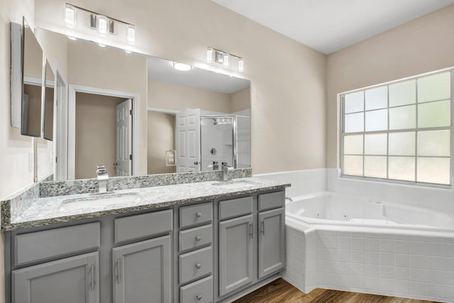 bathroom with vanity, hardwood / wood-style floors, and separate shower and tub