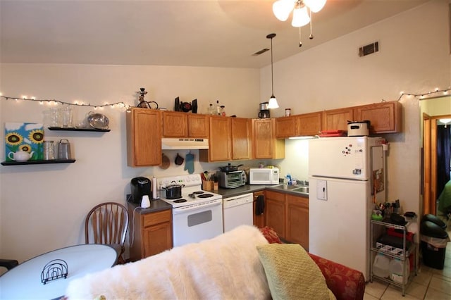 kitchen featuring sink, white appliances, light tile patterned floors, hanging light fixtures, and high vaulted ceiling