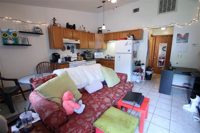 kitchen featuring white appliances, decorative light fixtures, high vaulted ceiling, and light tile patterned floors