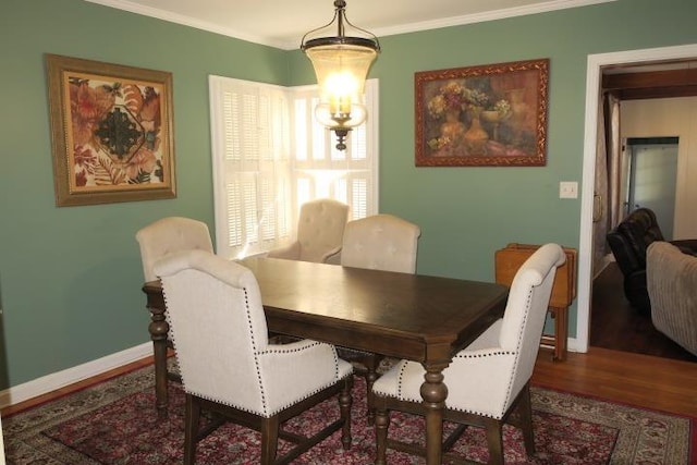 dining area with ornamental molding, hardwood / wood-style floors, and a chandelier