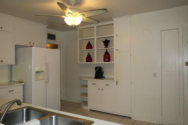 kitchen with white cabinetry, white fridge with ice dispenser, and light tile patterned flooring