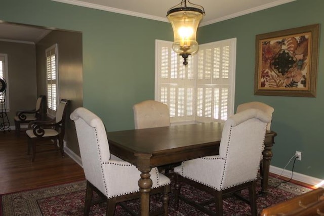 dining space with dark hardwood / wood-style floors and ornamental molding