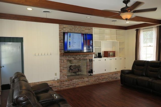 living room featuring a fireplace, hardwood / wood-style flooring, built in shelves, beam ceiling, and ceiling fan