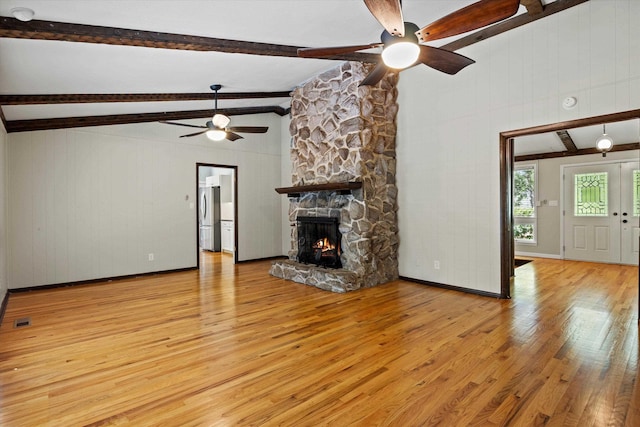 2521 Harriman Cir, Tallahassee, FL 32308 - unfurnished living room featuring ceiling fan, light wood-style floors, a fireplace, and wood walls