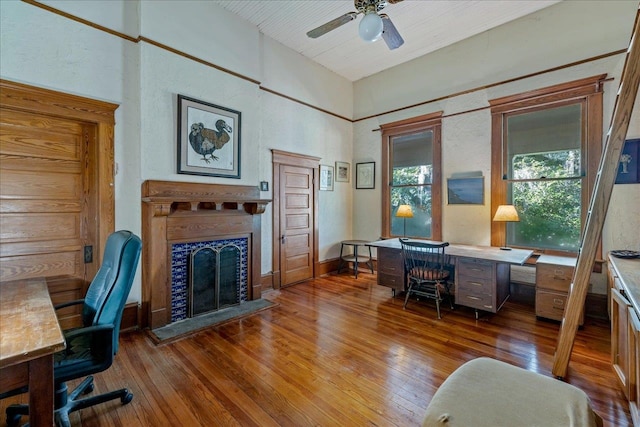 home office with hardwood / wood-style floors, a fireplace, and ceiling fan