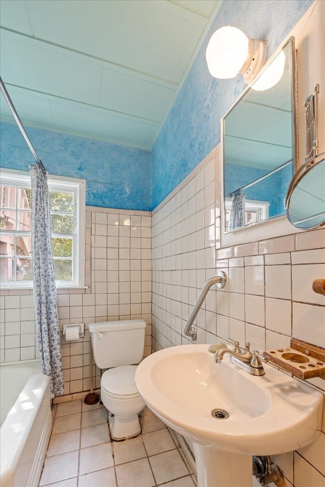 full bathroom with tile patterned flooring, sink, shower / bath combo, toilet, and tile walls