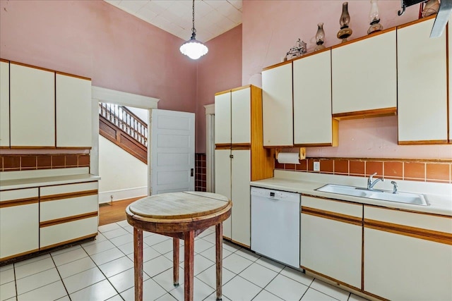 kitchen featuring hanging light fixtures, high vaulted ceiling, white cabinetry, and dishwasher