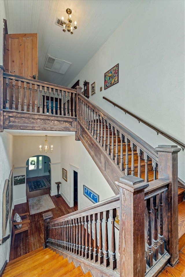 stairway featuring wood-type flooring and a chandelier