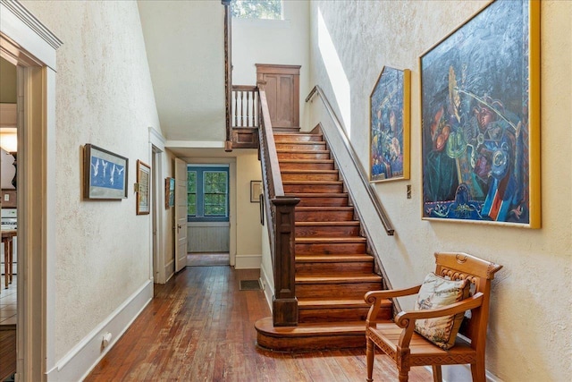 727 Miccosukee Rd, Tallahassee, FL 32308 - staircase featuring a high ceiling, hardwood / wood-style floors, a textured wall, and baseboards