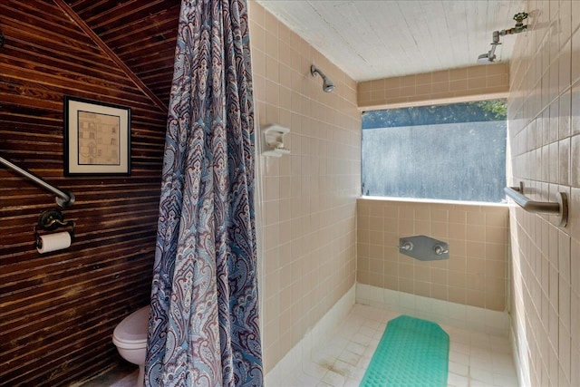 bathroom with tile walls, lofted ceiling, toilet, and a shower with shower curtain