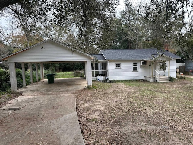 ranch-style house featuring a wall mounted AC and a carport