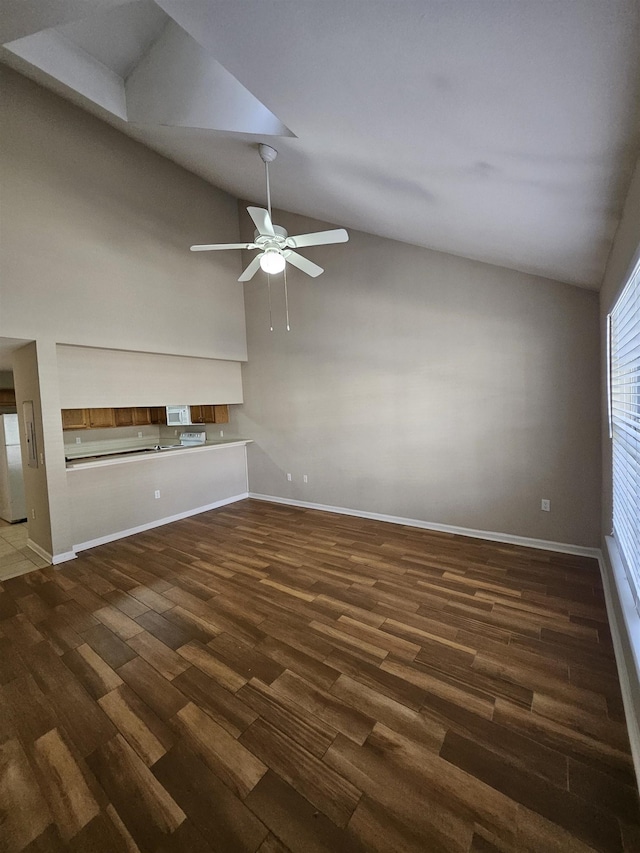 unfurnished living room featuring dark wood-type flooring, ceiling fan, and high vaulted ceiling