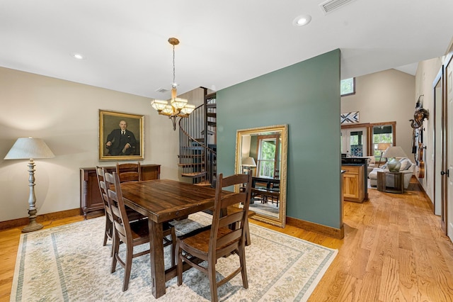 dining space featuring a notable chandelier, visible vents, light wood-style flooring, baseboards, and stairs