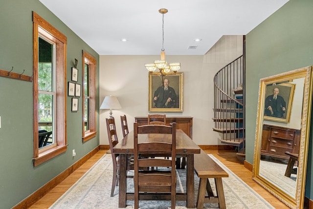 dining area with a notable chandelier, visible vents, baseboards, light wood-style floors, and stairway