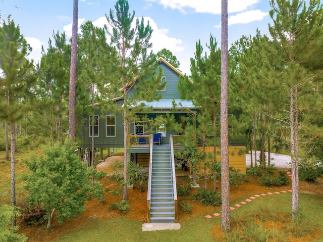 view of front of home with stairs and metal roof